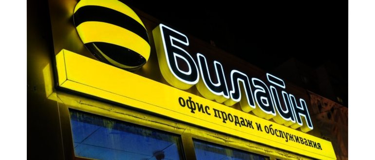 Девушка держит телефон в руке и сидит за