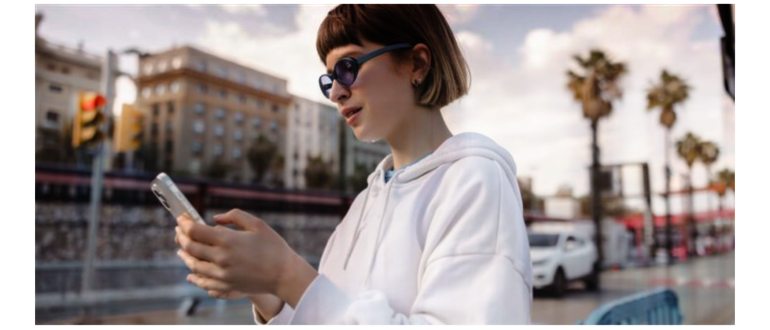 Девушка в очках с телефоном на фоне